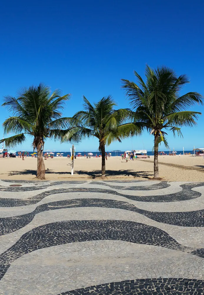 La playa de Copacabana con su paseo de mosaico y los morros al fondo
