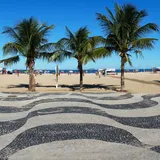 La playa de Copacabana con su paseo de mosaico y los morros al fondo