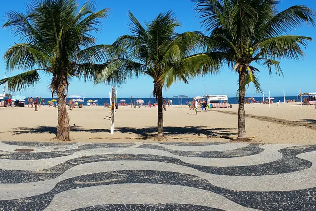 La playa de Copacabana con su paseo de mosaico y los morros al fondo